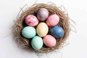 a bird's nest filled with colored eggs on a white background with clippings to the top of the eggs and the bottom half of the eggs in the nest.