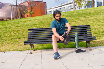 Physically disabled male runner adjusting prosthetic leg