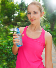 Woman drinking water after fitness exercise