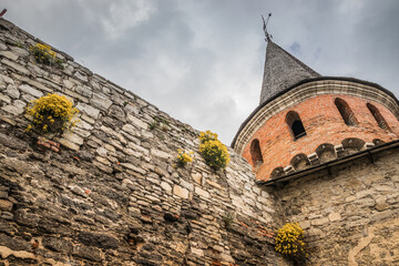 Fortifications and towers near the Kamianets-Podilskyi Castle. Part of the powerful bastions of the castle. The fortress located among the picturesque nature in the historic city of Kamianets-Podilsky - obrazy, fototapety, plakaty
