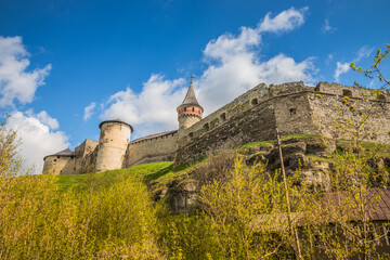 Old Kamianets-Podilskyi Castle under the blue sky. Part of the powerful bastions of the castle. The...