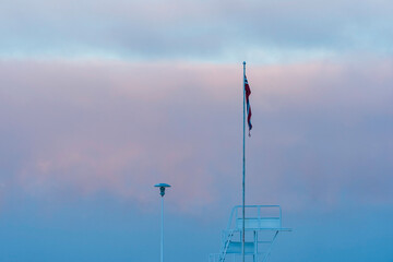 The Panengen jetty with the Norwegian flag and the diving tower in front of the Lake Mjosa mist in...