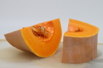 whole and half butternut squash isolated on white background. Slices of pumpkin on a white background, close-up.