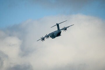 Fototapeta na wymiar RAF Royal Air Force Airbus A400M Atlas military cargo plane on a low-level cargo parachute drop exercise, rear door open, banking and flying away. Wilts UK