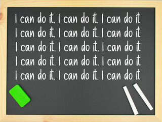 Blackboard with the words I can do it repeated a few times written in white with two chalks and a green eraser