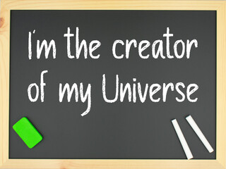 Blackboard with the words I´m the creator of my universe written in white with two chalks and a green eraser