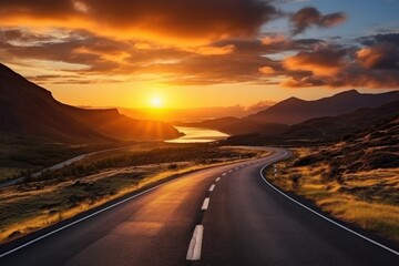  the sun is setting over the mountains and a road in the foreground is a body of water with a body of water in the middle of water in the distance.