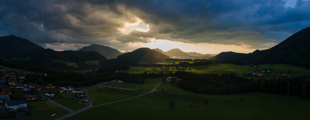 Fototapeta premium Dramatic Sunset Over a Charming Alpine Village and Church in the Austrian Alps