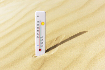 Hot summer day. Celsius scale thermometer in the sand. Ambient temperature plus 36 degrees