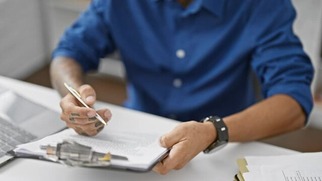 Handsome young latin man excels at his work, confidently signing business contract in office as successful worker