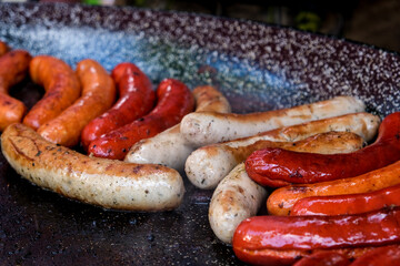 ..Cooking different types of sausages on the grill. Delicious sausages close-up.
