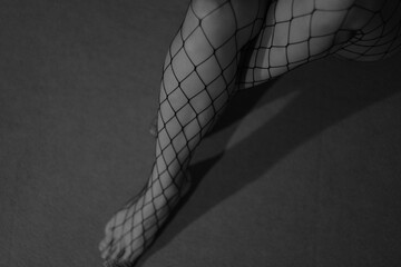 Women's legs in fishnet tights.