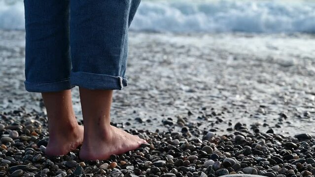 Female feet step on the sea wave
