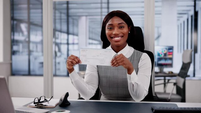 Business Woman Holds Checkbook, Examining Paycheck