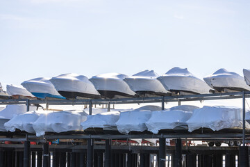 Shrink wrapped power boats on storage racks