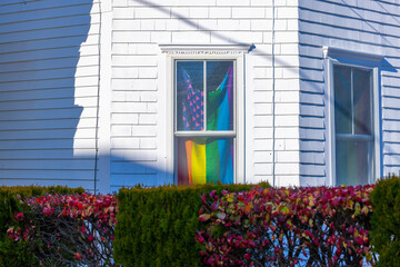 Rainbow / Pride flag in window of white clapboard house, Provincetown