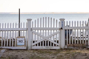 Picket fence and gate with private property sign ocean in background
