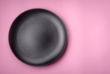 Empty round ceramic plate on a plain background, flatley with copy space