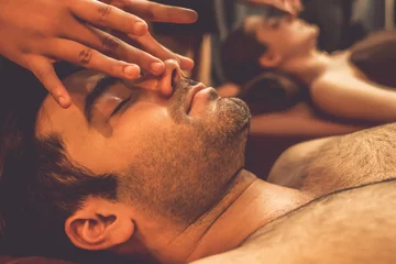 Tuinposter Couple customer enjoying relaxing anti-stress head massage and pampering facial beauty skin recreation leisure in warm candle lighting ambient salon spa in luxury resort or hotel. Quiescent © Summit Art Creations