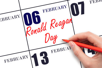 February 6. Hand writing text Ronald Reagan Day on calendar date. Save the date.