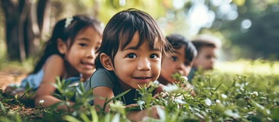 Kindergarten children resting happily on park grass.