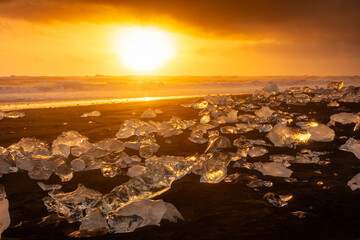 Amazing sunset over the Diamond Beach, volcanic black beach with icebergs from the Jokulsarlon...