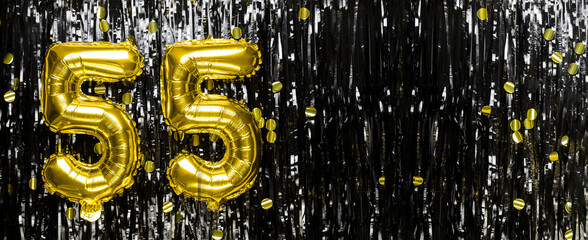 Gold foil balloon number number 55 on a background of black tinsel decoration. Birthday card,...