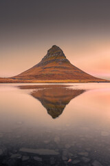 Amazing sunset view of the Kirkjufell. Symmetric reflection over the lake,  Iceland