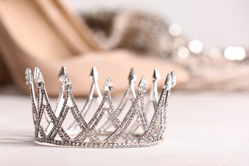 Beautiful crown on white table, closeup. Prom concept