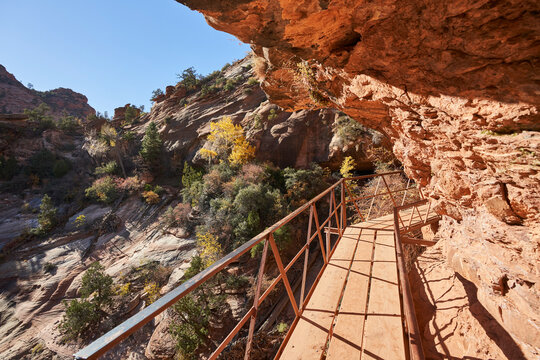 A boardwalk wraps around a steep rock overhang as the trail continues to canyon overlook. It is a very popular trail in zion national park