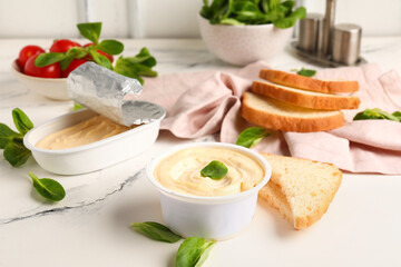 Boxes of processed cheese, toasts and vegetables on white grunge table near wall