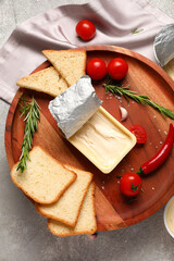 Plastic container with tasty cream cheese, bread and tomatoes on grey background