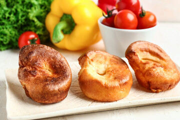 Plate with tasty Yorkshire pudding on light background