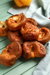 Tasty Yorkshire pudding on green wooden background