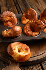 Baking tin with tasty Yorkshire pudding on wooden background