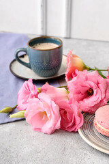 Beautiful pink eustoma flowers, plate with macaroon and cup of coffee on white table