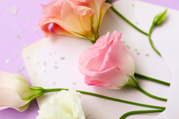 Obraz na płótnie Canvas Blank envelope with beautiful eustoma flowers and confetti on purple background, closeup
