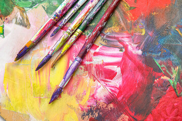 Obraz premium Dirty paint brushes on colorful background