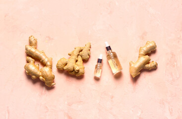 Bottles of ginger cosmetic oil on pink background