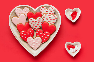 Bowl with heart shaped sweet cookies on red background. Valentine's day celebration