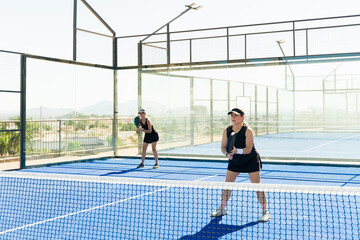 Couple of women playing a padel match together