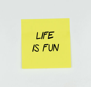 Yellow Post-it with the phrase llive is fun written in black, with a white background