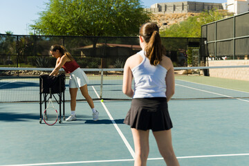 Caucasian teen girl and tennis coach during a practice game - obrazy, fototapety, plakaty