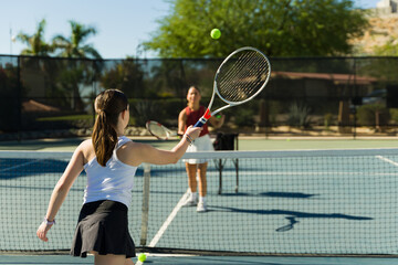 Teen girl playing a tennis match on the court
