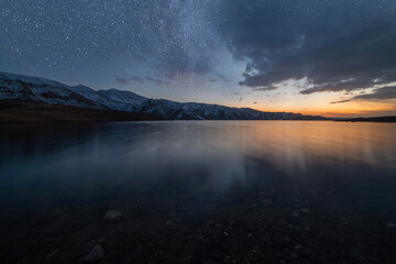 Beautiful night landscape. Small lake and mountains in the starry night.