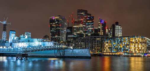 Night view of HMS Belfast, a town-class light cruiser that was built for the Royal Navy, moored as...