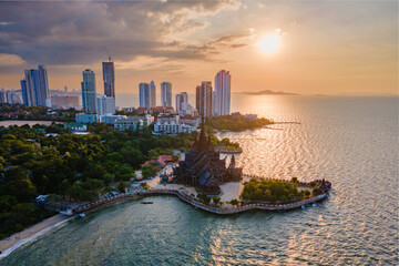 Skyline of Pattaya city at sunset with The Sanctuary of Truth wooden temple in Pattaya Thailand is...