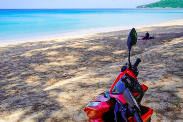 motorbike on the beach in Thailand. Blue sea and yellow sand. There is space for text for your advertisement
