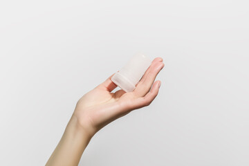 female hand holding mineral potassium alum crystal stick. natural deodorants concept - obrazy, fototapety, plakaty
