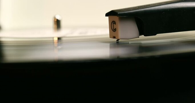 Vinyl record close-up. Vintage old vinil black phonograph spinning. Retro music player on living room home background in evening.